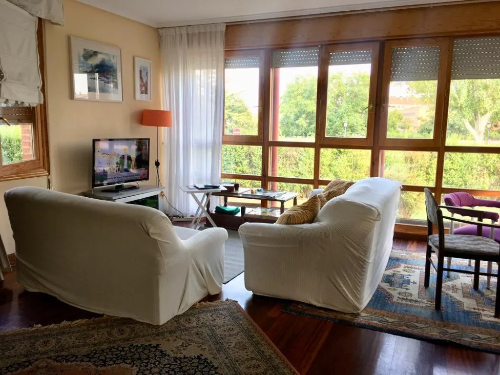 Salón con ventanal y sofás blancos