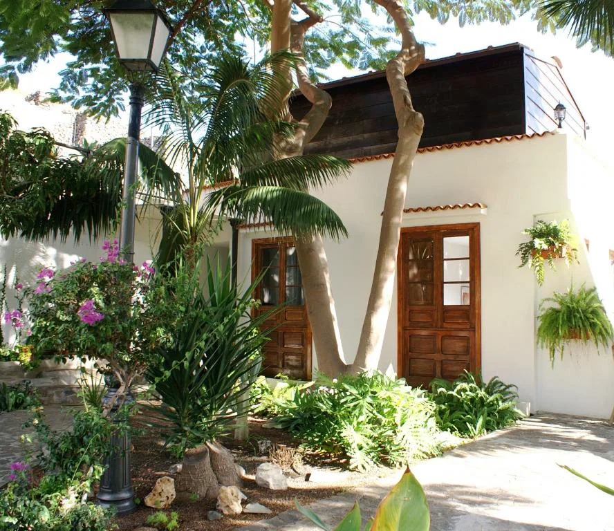 Fachada blanca con palmera y buganvillas de Casa Creativa, en Hermigua, La Gomera