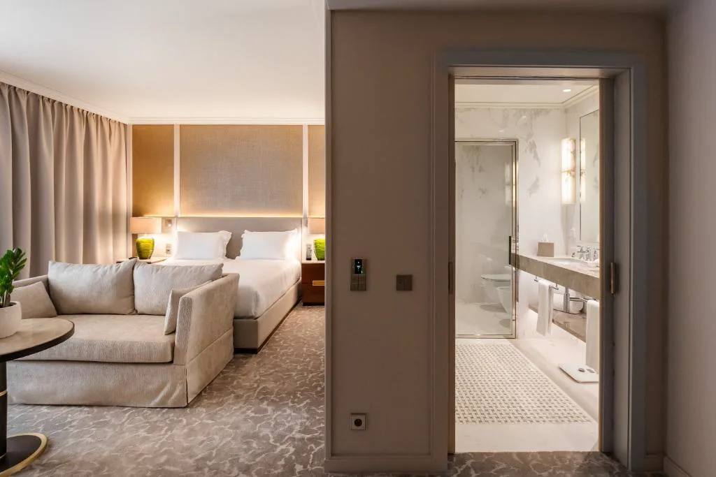 Suite con salón, sofá y baño de mármol con ducha de cristal, Casa da Calçada