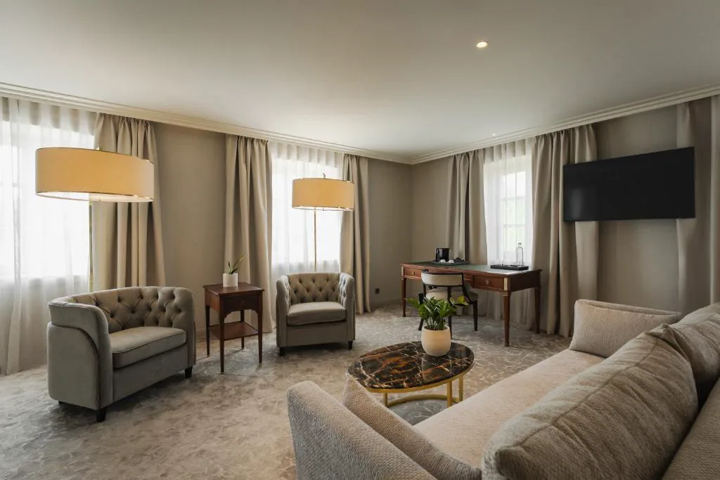 Salón de la suite con sofás, mesa de centro y escritorio clásico, Casa da Calçada