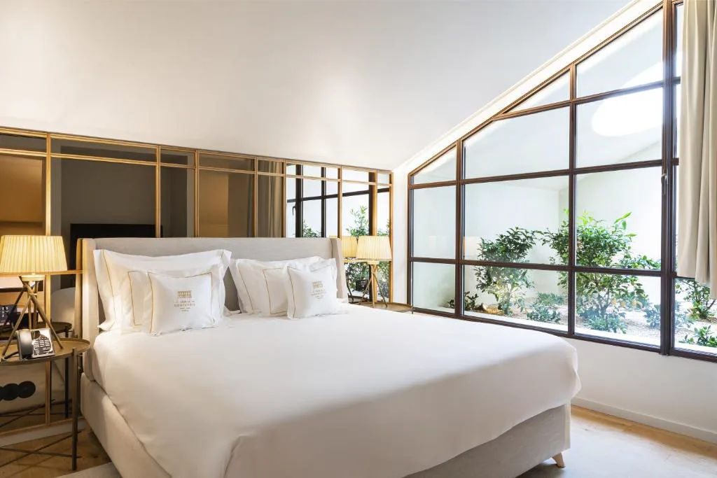 Suite con ventanal en ángulo y patio interior ajardinado, Casa da Companhia