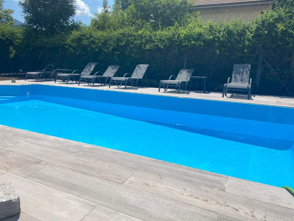 Piscina con tumbonas entre setos y vistas