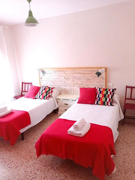 Dormitorio con camas y cojines rojos
