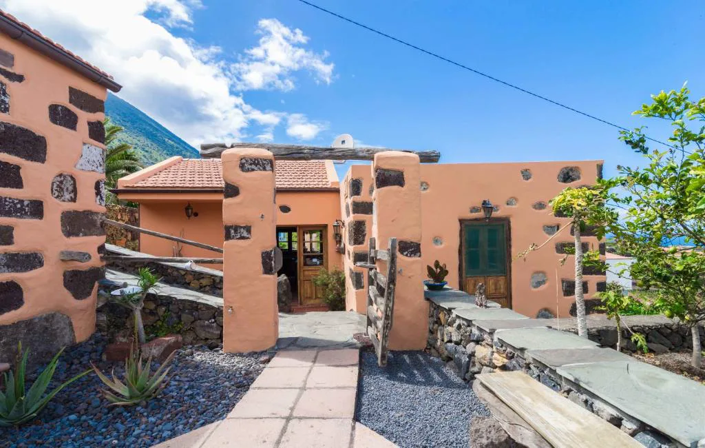 Entrada de la casa con arcos de piedra volcánica y jardín de áloes, Casa de Mi Abuela Maria