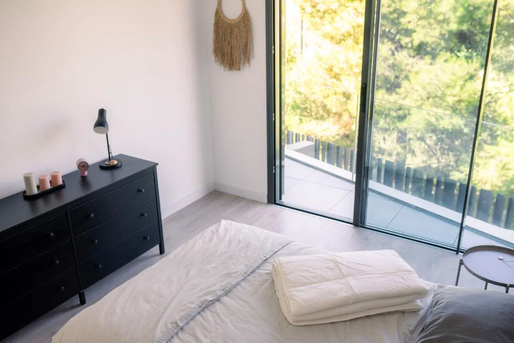 Dormitorio con ventanal a los árboles