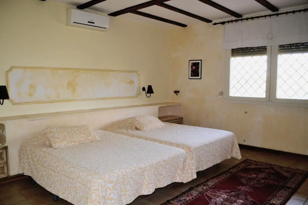Dormitorio con paredes de estuco veneciano y dos camas individuales, Casa del Artista