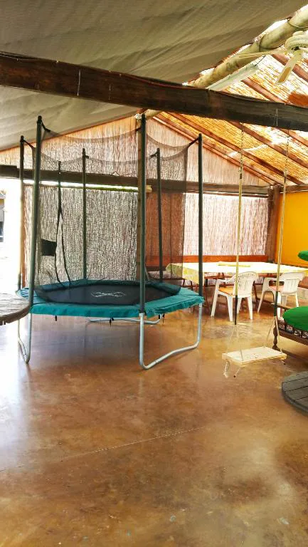 Porche cubierto de cañizo con mesas junto al jardín, Casa del Artista
