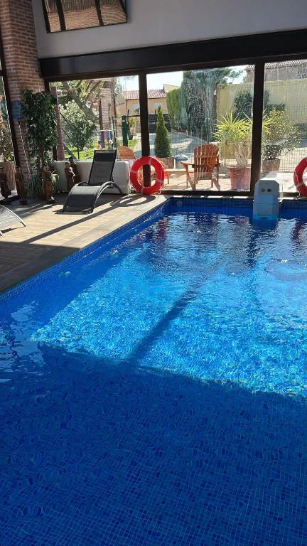 Piscina cubierta con cristalera y ventanas de tonos cálidos