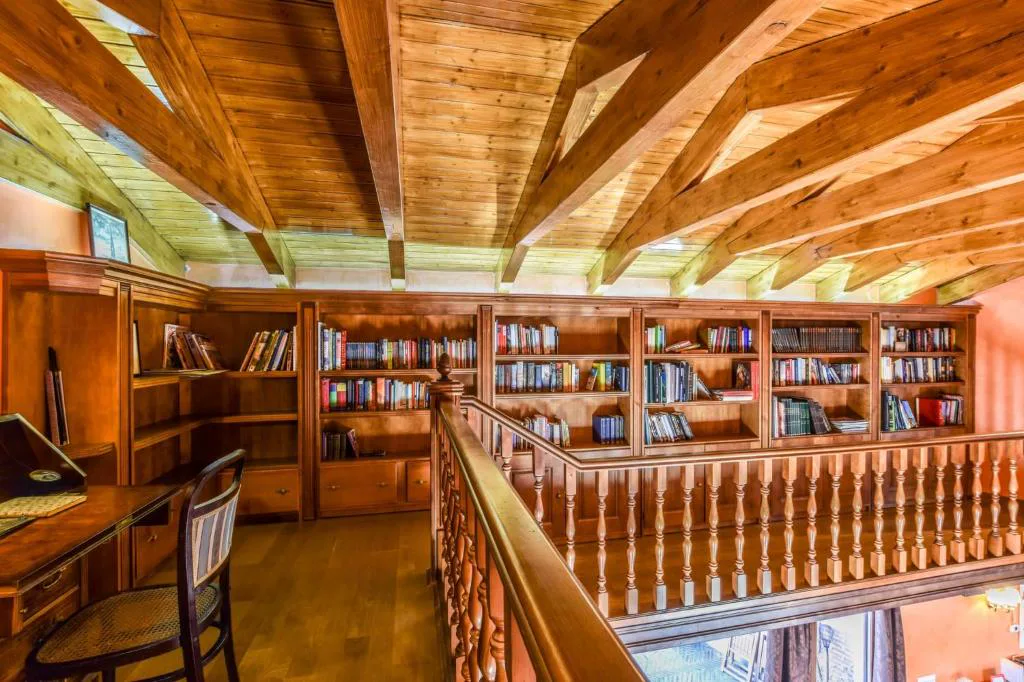 Biblioteca de madera en el altillo con barandilla torneada