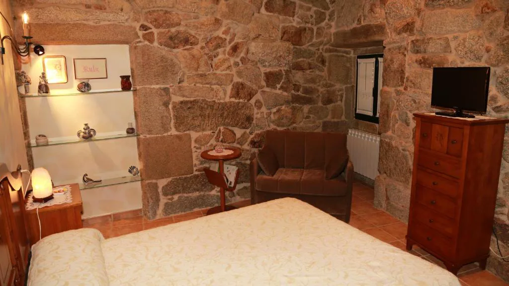 Dormitorio de piedra con estanterías de cristal y lámpara de sal, Casa do Sear
