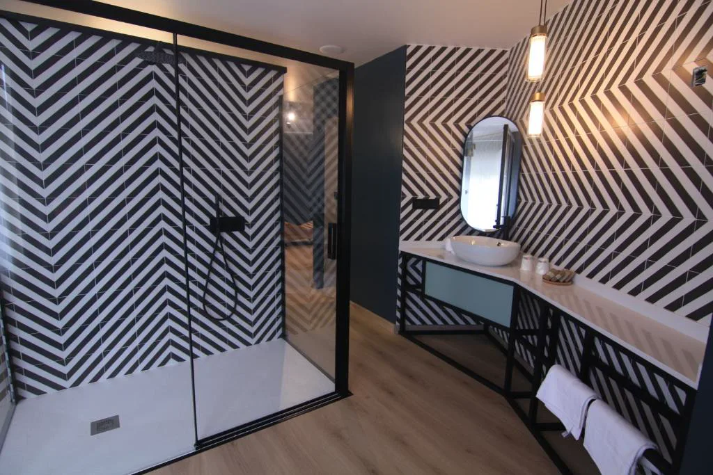 Baño con ducha de azulejo geométrico blanco y negro, Casa dos Americanos