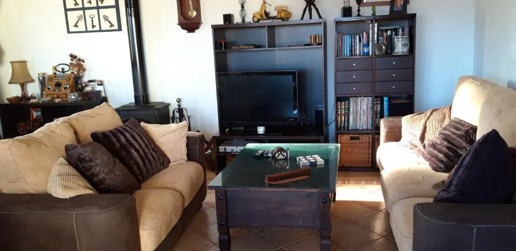Salón con dos sofás enfrentados y estanterías de madera, Casa El Horno