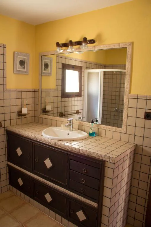 Baño en tonos amarillos con azulejos de mosaico tradicional, Casa El Horno
