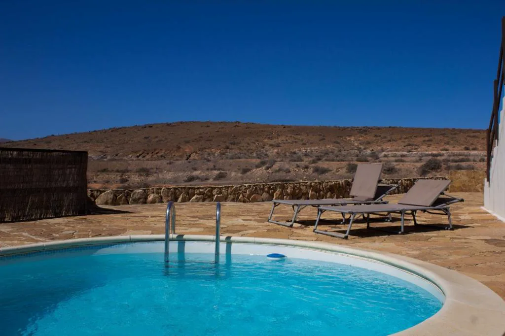 Piscina circular frente al paisaje volcánico desértico, Casa El Horno, en Triquivijate, Antigua, Fuerteventura