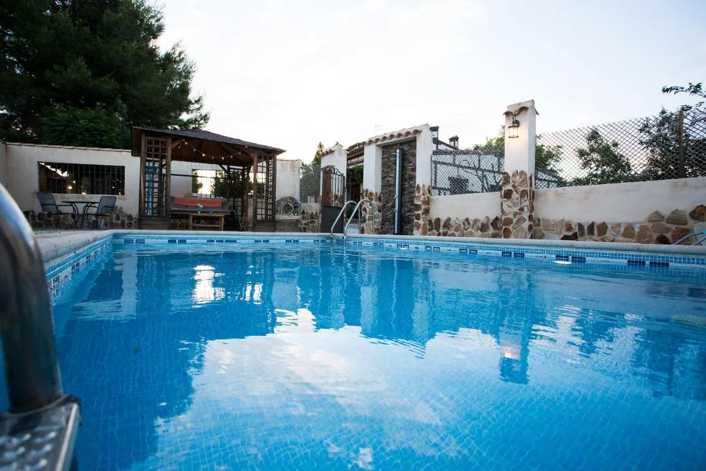 Piscina rectangular con luz cálida junto a la casa