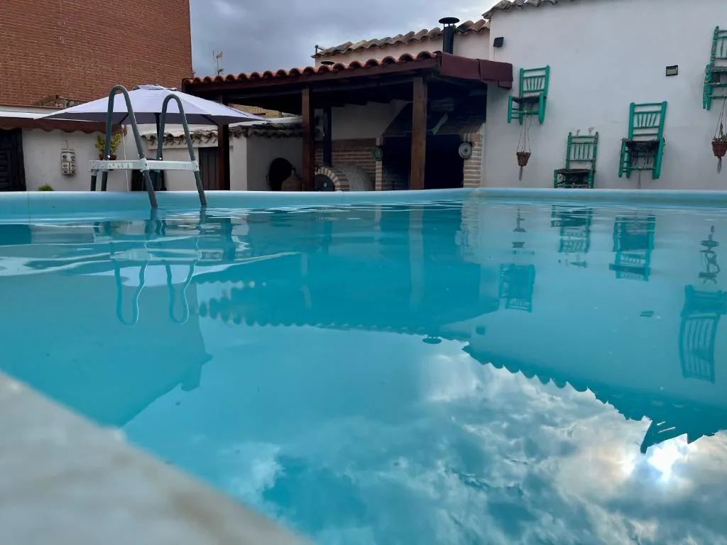 Piscina grande de agua clara junto a la casa