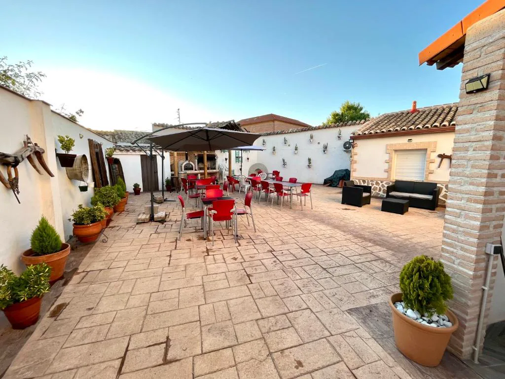 Patio con sombrillas, sofás rojos y macetas