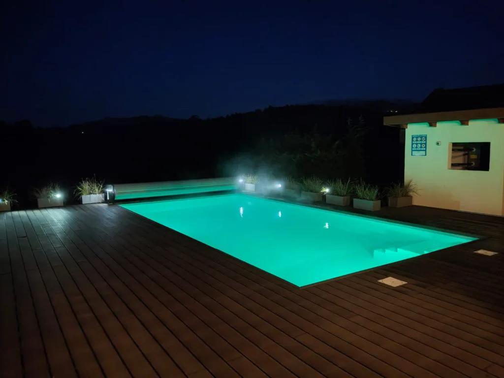 Piscina iluminada de noche con luz turquesa