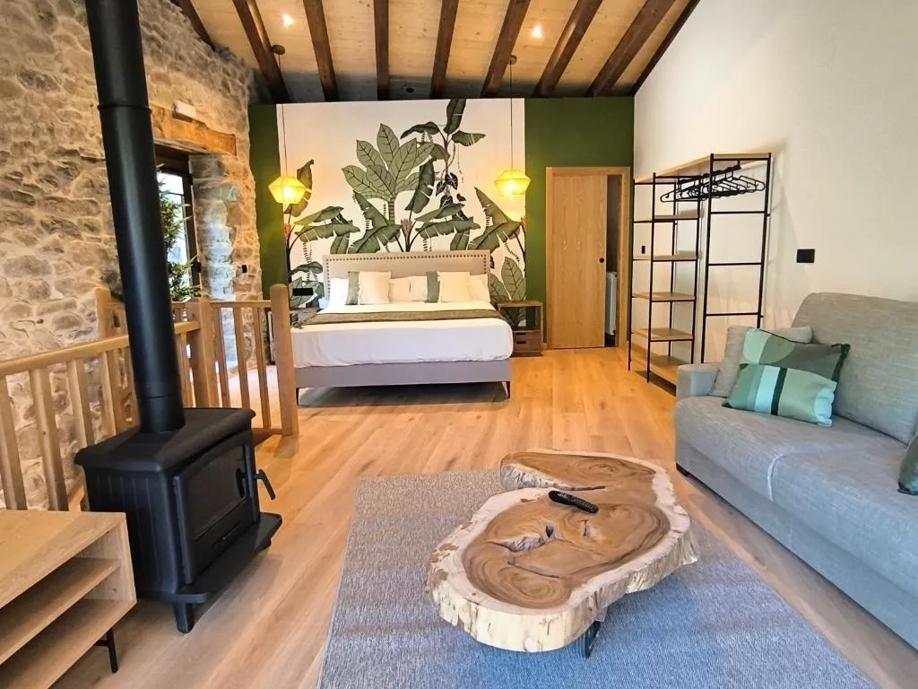 Dormitorio con estufa de leña y pared con mural botánico, en Casa Escondida Aveiga