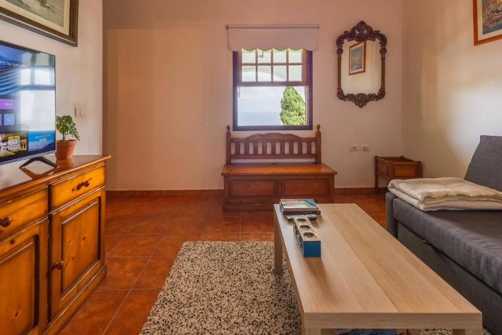 Salón con muebles antiguos y ventana con vistas al mar, Casa de Los Establos
