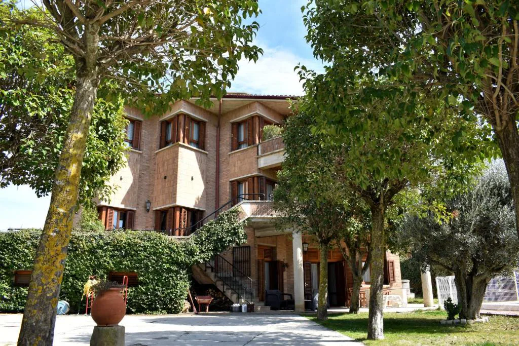 Casa entre árboles con jardín amplio