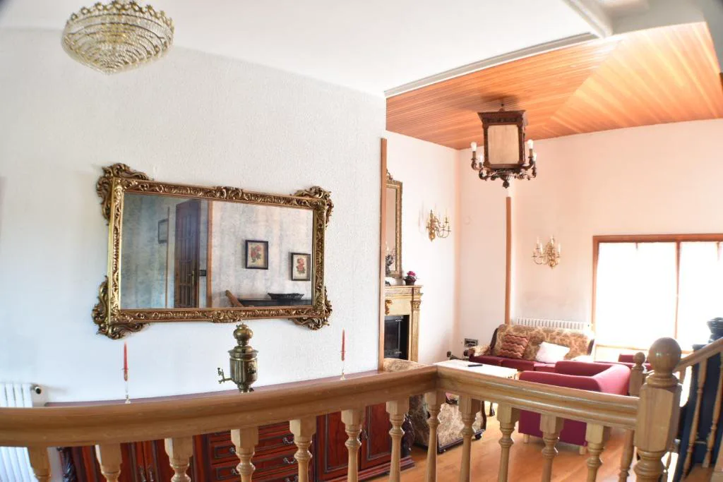 Salón con espejo y escalera de madera