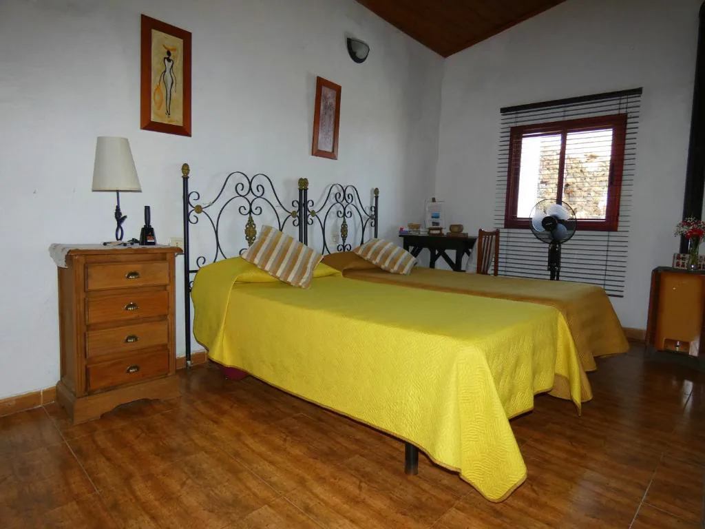 Segundo dormitorio con cabecero de forja y ventana con vistas al campo, Casa Goliath