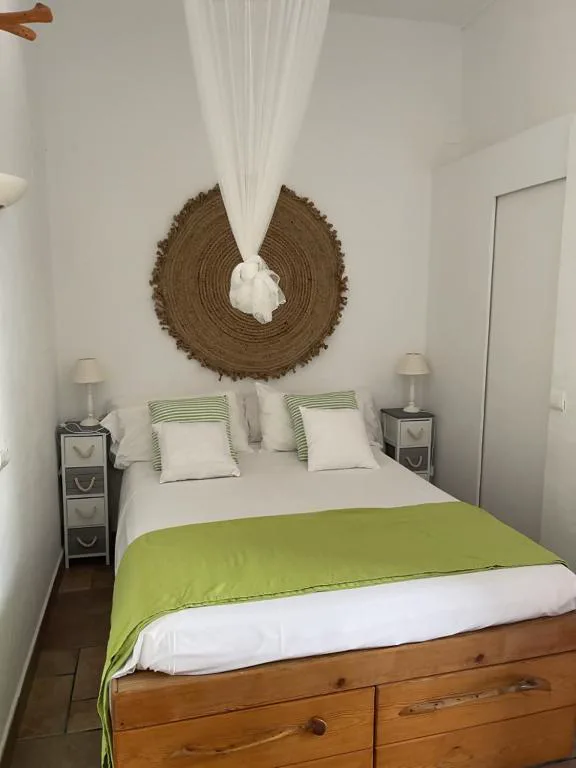 Dormitorio en tonos verdes con cabecero de fibra tejida, Casa Goro
