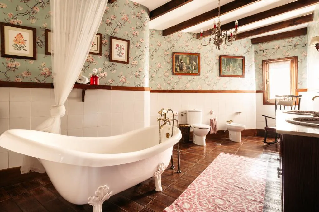 Baño con bañera exenta de patas y papel pintado floral vintage, Casa Juan Vera