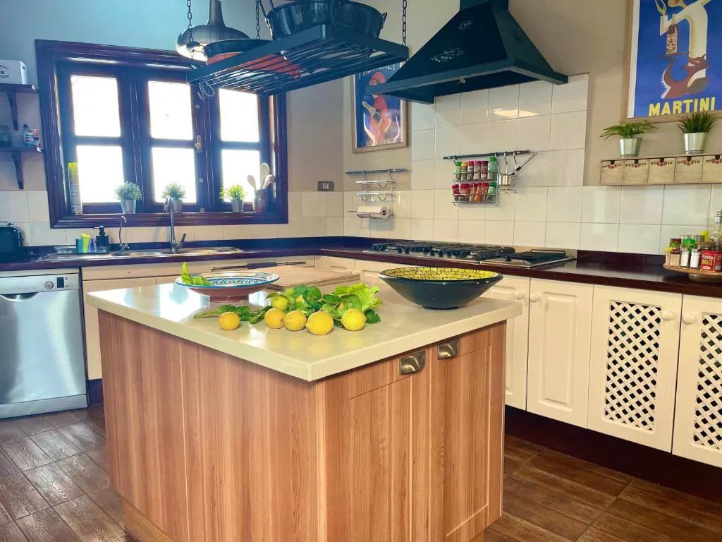 Cocina con isla de madera y limones frescos sobre la encimera, Casa Juan Vera