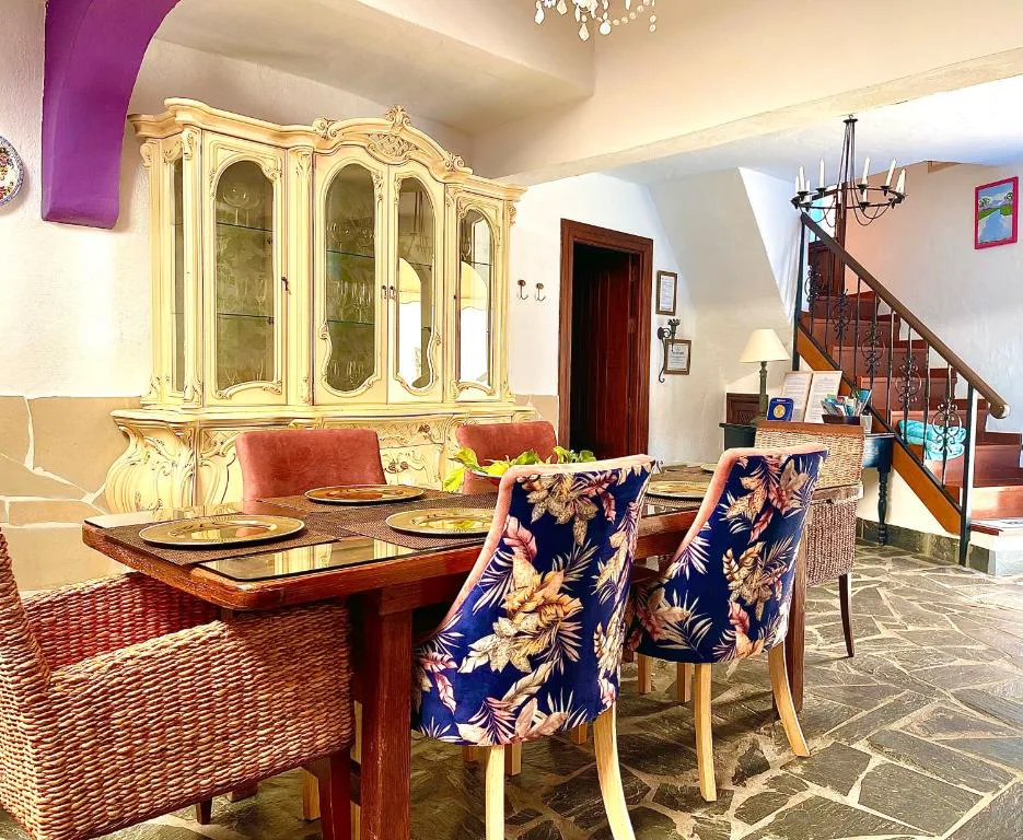 Comedor con vitrina antigua dorada y sillas de terciopelo estampado, Casa Juan Vera