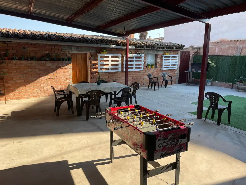Patio con futbolín y mesas bajo cubierta