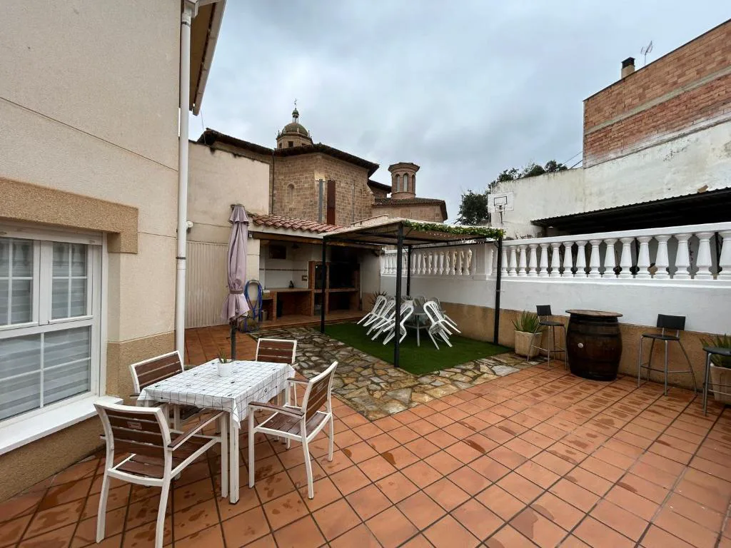 Patio con mesa y sillas junto a la torre