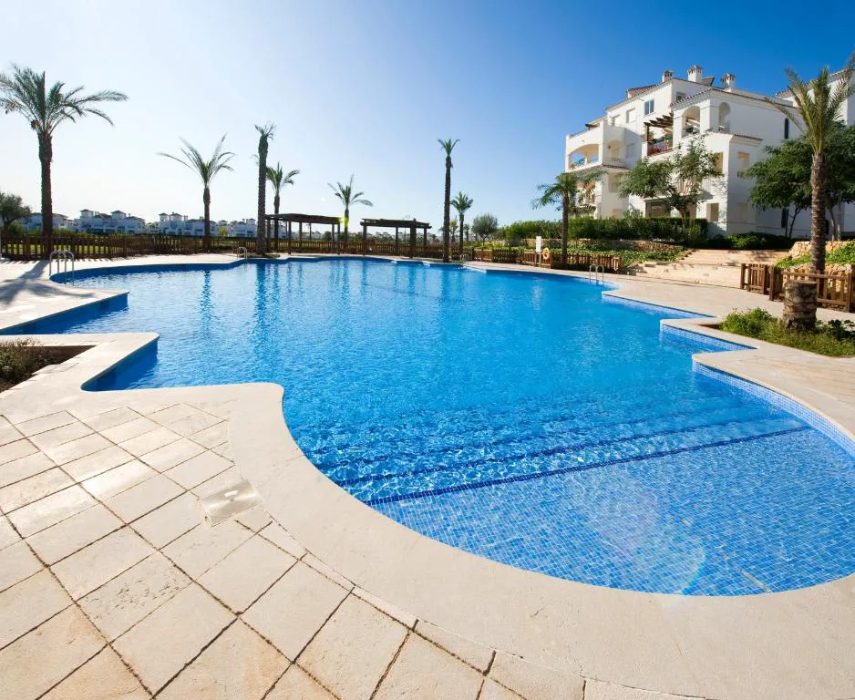 Piscina comunitaria azul junto a los edificios del resort