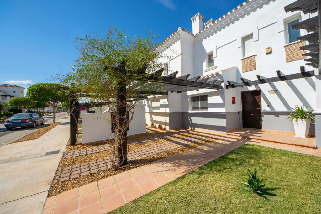 Casas blancas con jardín y pérgola