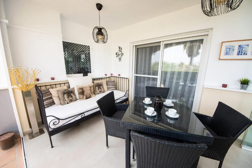 Salón blanco con mesa de comedor y sillón
