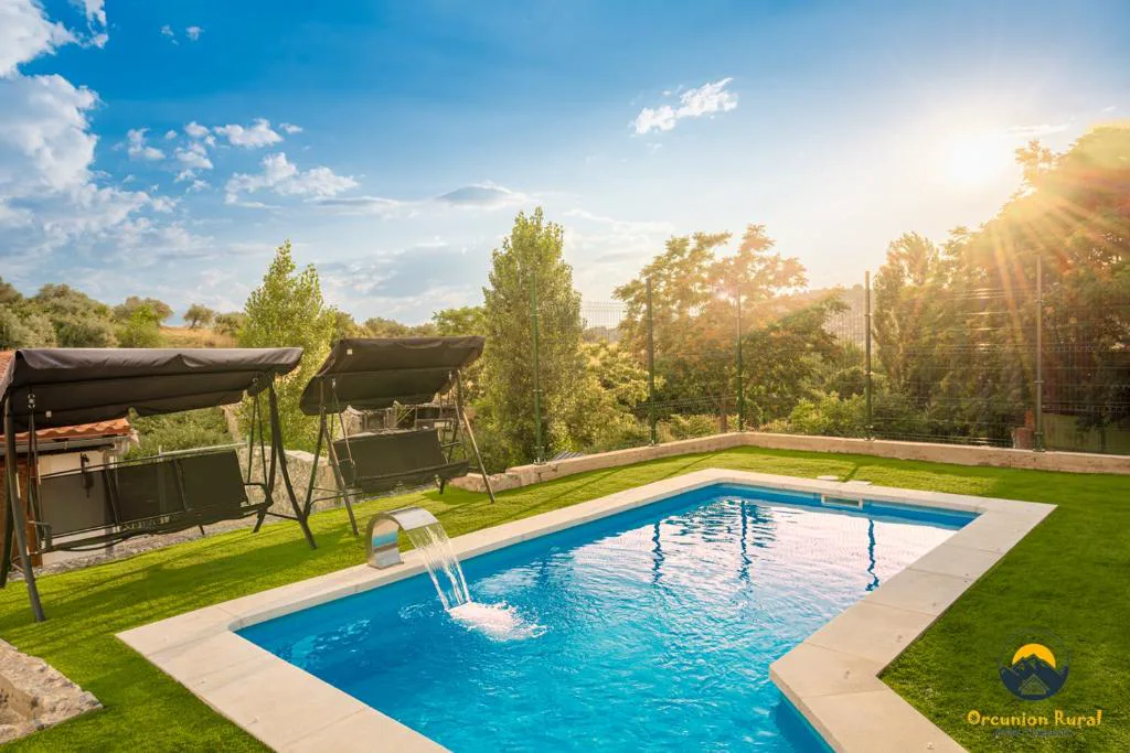 Piscina con cenador de madera en un jardín