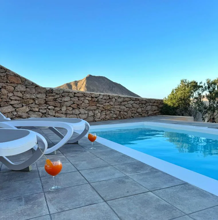 Copas de cóctel junto a la piscina al atardecer con vistas a la montaña, Casa Marisa
