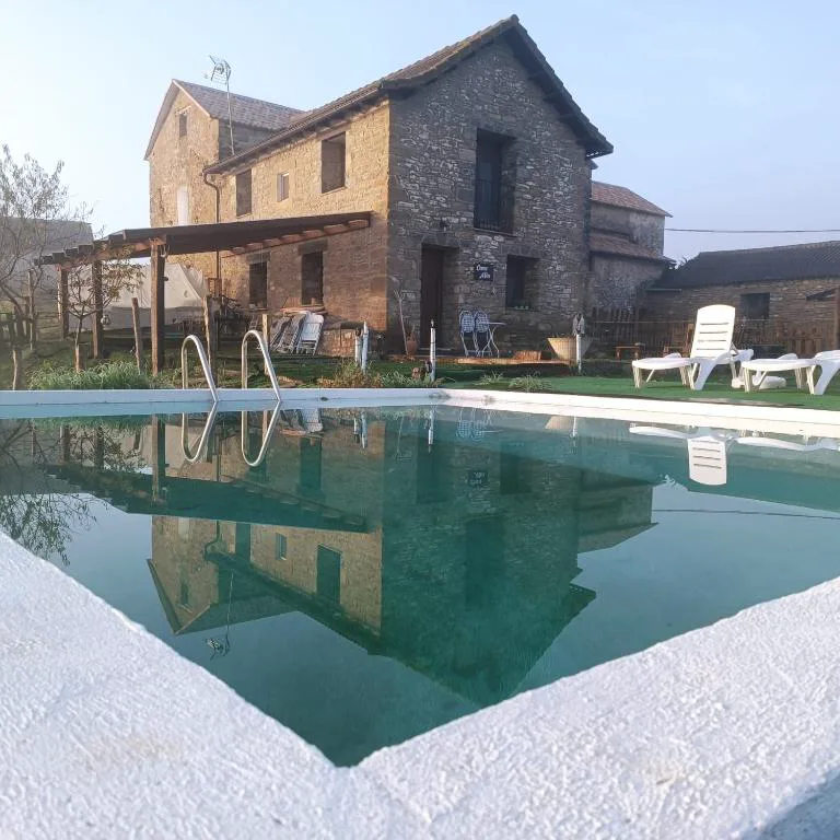 Piscina larga con casas de piedra al fondo