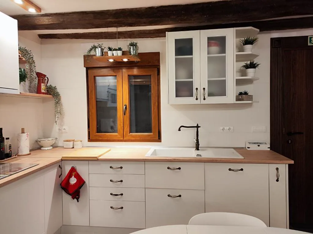 Cocina blanca con vigas y armarios de madera