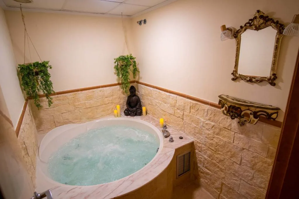 Bañera de hidromasaje redonda en una sala con paredes claras