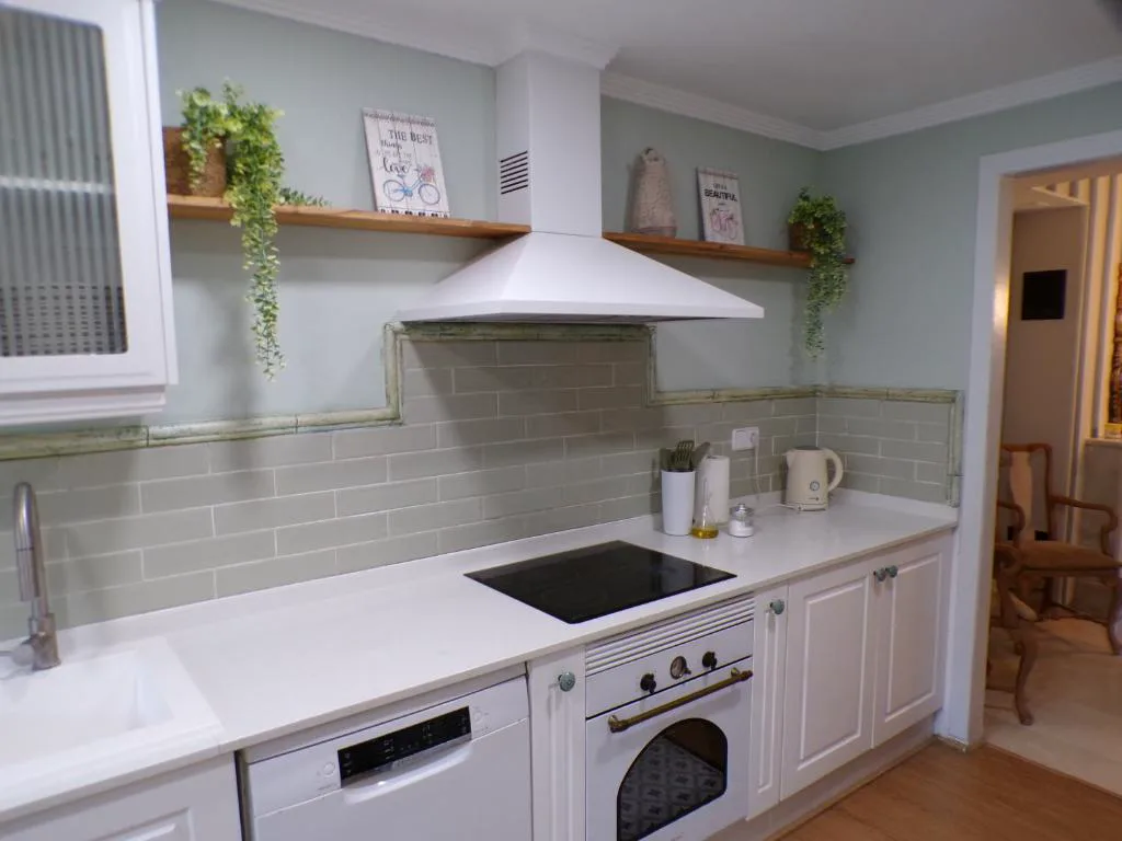 Cocina blanca con encimera y taburetes