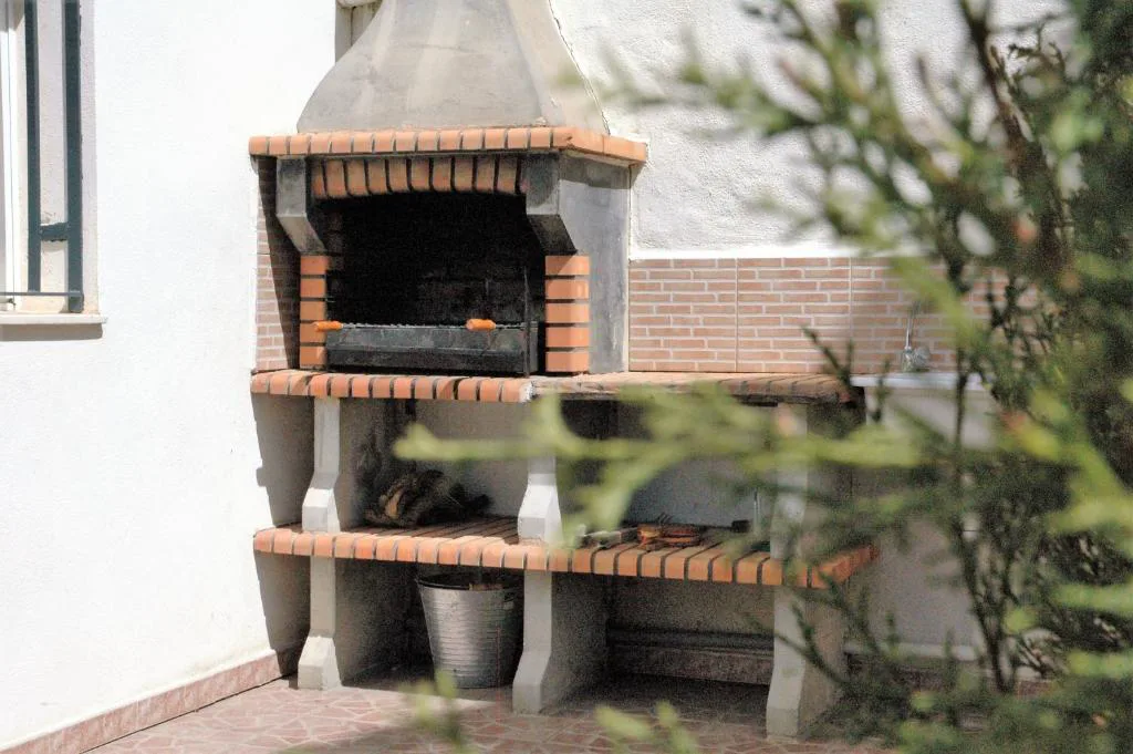 Barbacoa de obra con chimenea en el patio