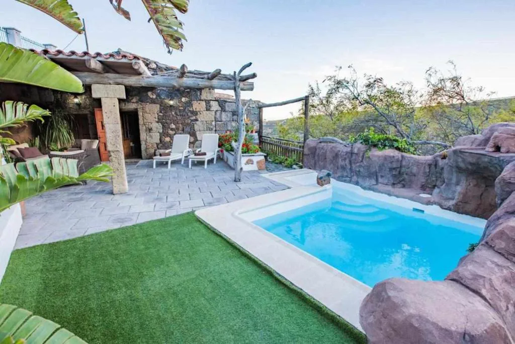 Piscina excavada en roca volcánica junto a una casa de piedra, Casa Oronado, en Ingenio, Gran Canaria