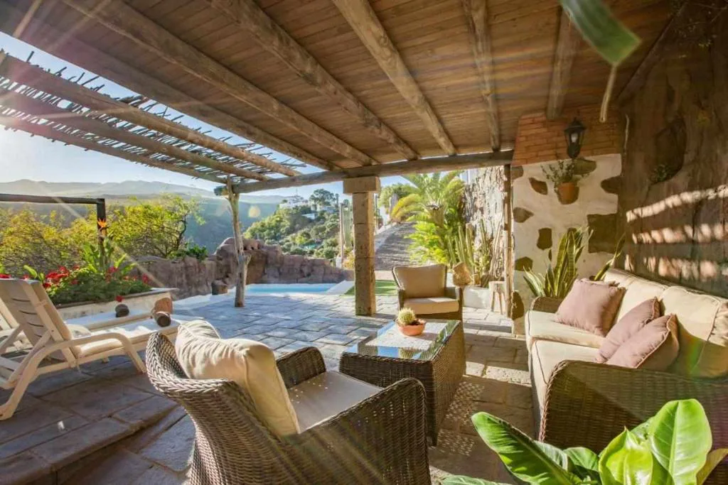 Porche de cañizo con sofás de mimbre y vistas al valle, Casa Oronado