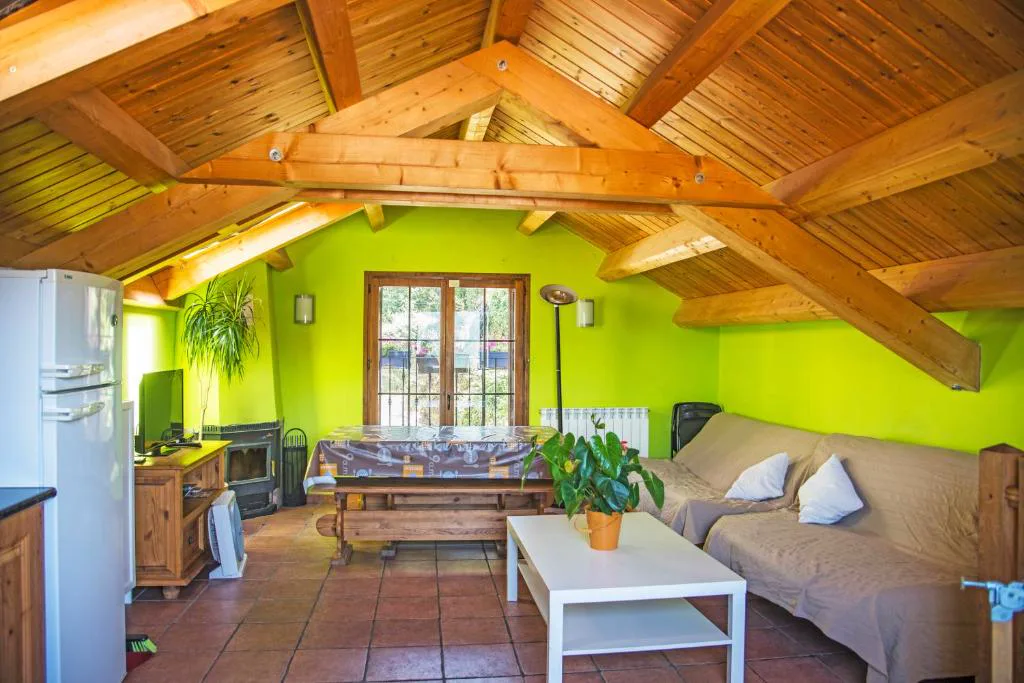 Salón con paredes verdes y vigas de madera