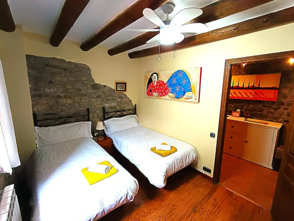 Habitación con dos camas y cuadros de colores
