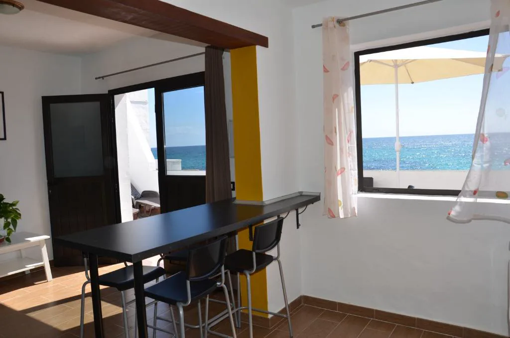 Salón comedor con vistas al mar a través de ventanales, Casa de la playa