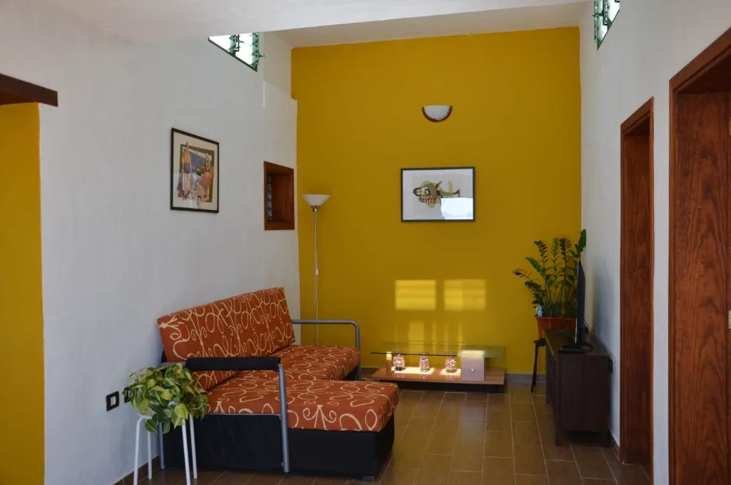 Salón con sofá naranja y pared amarilla, Casa de la playa