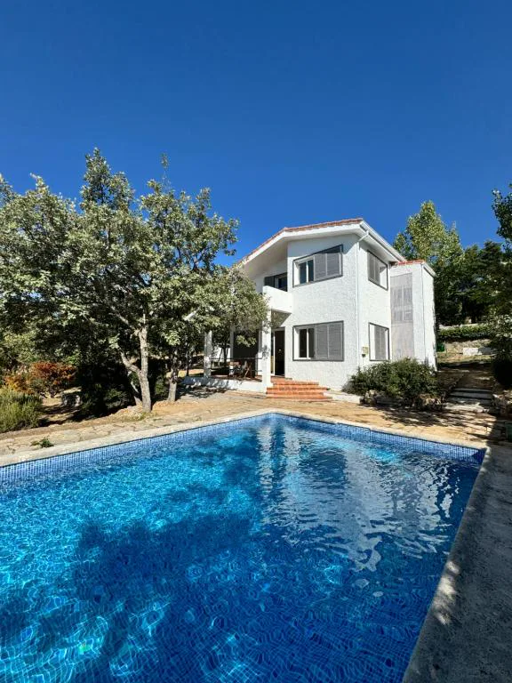 Casa de piedra y ladrillo con terraza de mesa blanca y sillas